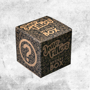 Mystery Box Jano Filters negra y dorada con motivos de interrogación